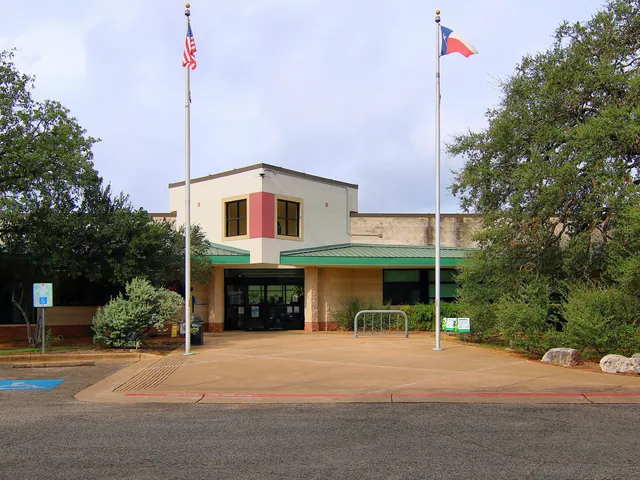 The entrance of the Hampton Branch of the Austin Public Library, framed by trees